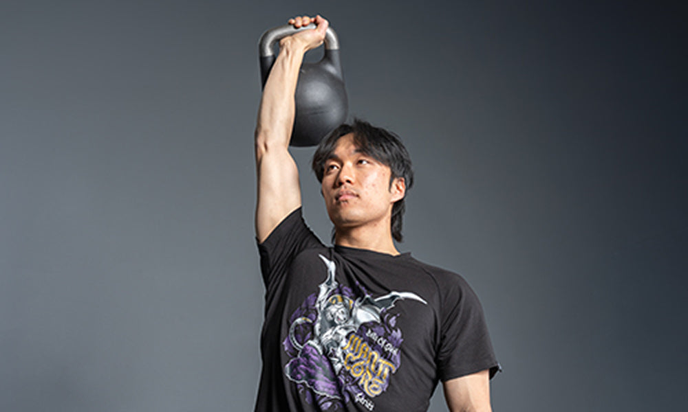 Athlete pressing a Bells of Steel kettlebell overhead