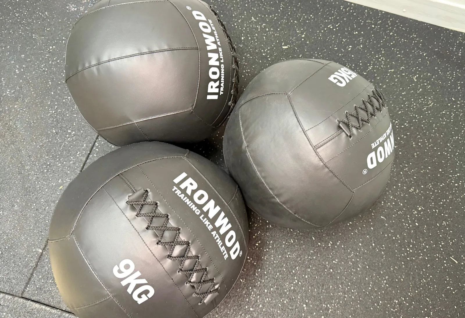 Photo showing real world photo of 3 9kg wall balls on a matting piece